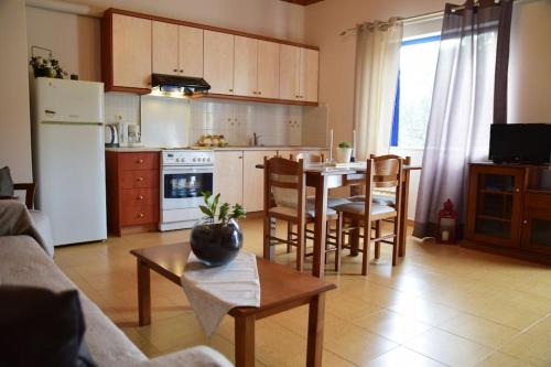 a kitchen and living room with a table and chairs at Affordable vintage apartment near Fiscardo & Assos in Fiskardho