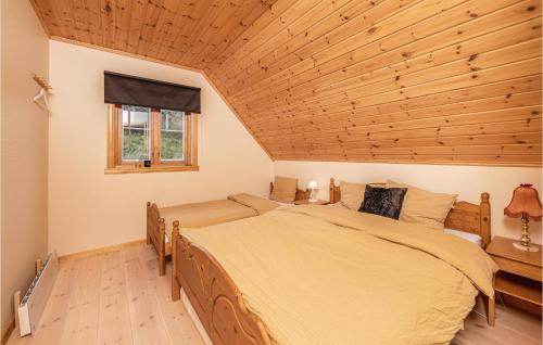 a bedroom with a large bed and a wooden ceiling at Lovely Home In Kvamsy With Jacuzzi in Sandvik