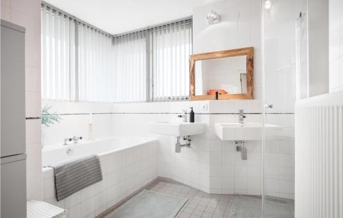 ein Badezimmer mit zwei Waschbecken, einer Badewanne und einem Spiegel in der Unterkunft Villa Topduin in Bergen aan Zee