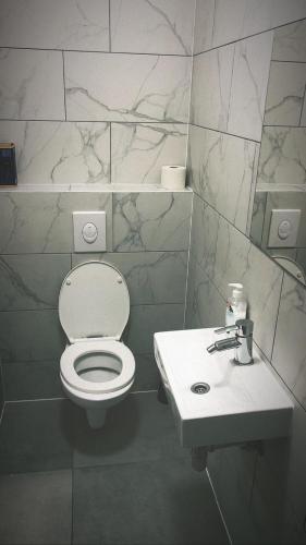 a bathroom with a white toilet and a sink at Aparthotel MERDIAN in Vienna
