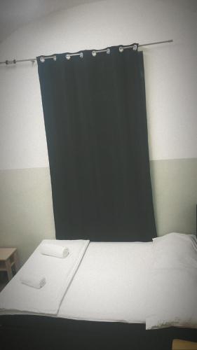 a bed in a room with a black curtain at Aparthotel MERDIAN in Vienna