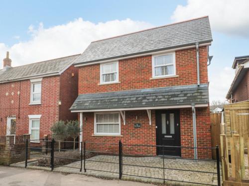 a brick house with a black roof at Lilac Cottage in Lymington