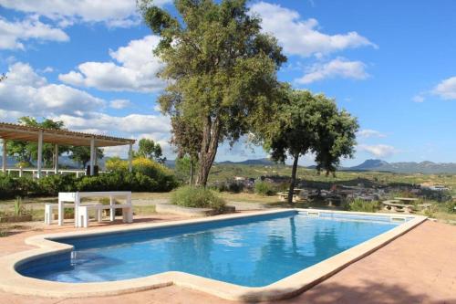 una piscina en un patio con mesa y árboles en Rocaplana Club de Campo, en Vilarrodona