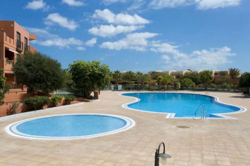 a swimming pool in an apartment complex with a blue at Apartment in La Tejita 2 in La Tejita