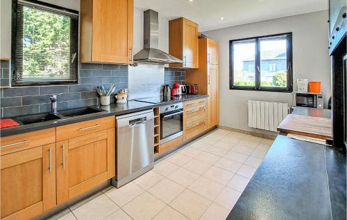 une cuisine avec des armoires en bois et des appareils en acier inoxydable dans l'établissement Awesome Home In Gonneville-S,-Honfleur, à Gonneville-sur-Honfleur