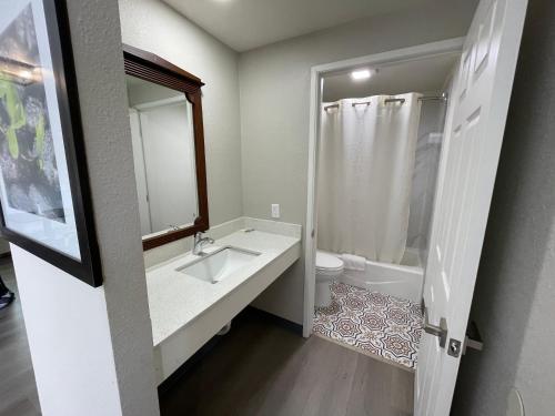 uma casa de banho com um lavatório, um WC e um espelho. em VILLA INN em Anaheim