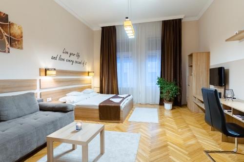 ein Wohnzimmer mit einem Sofa und einem Bett in der Unterkunft City Center Apartment Debrecen in Debrecen