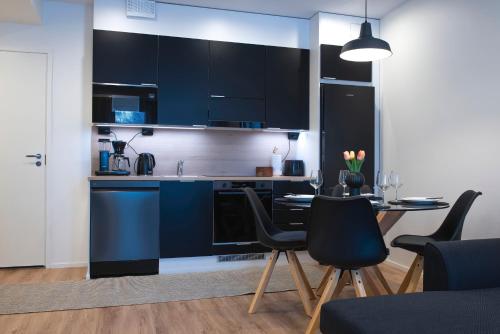 uma cozinha com armários pretos e uma mesa e cadeiras em Otava em Rovaniemi