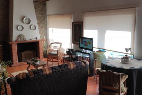 a living room with a couch and a table at Casa de Campo - Casa da Ribeira in Serapicos