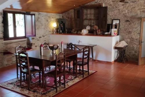 kuchnia i jadalnia ze stołem i krzesłami w obiekcie Casa de Campo - Casa da Ribeira 