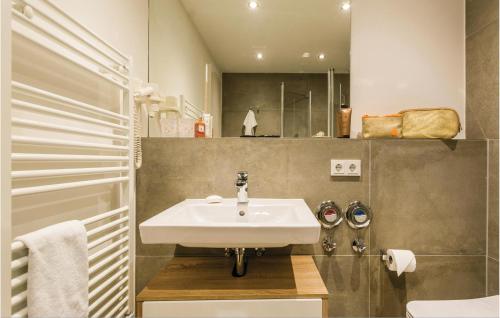 La salle de bains est pourvue d'un lavabo blanc et d'une douche. dans l'établissement Penthouse Garden, à Binz