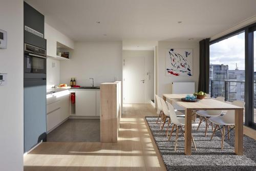 a kitchen and dining room with a table and chairs at Kustappartementen in Blankenberge