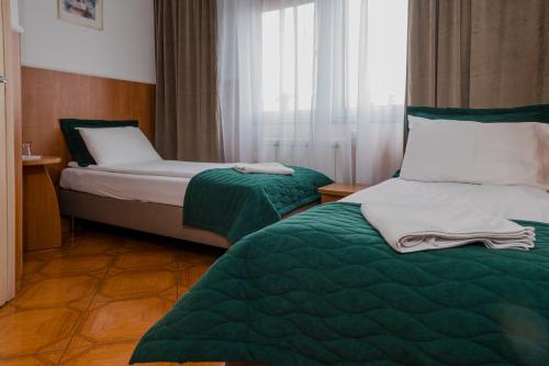 a hotel room with two beds and a window at Zajazd Błonie in Błonie