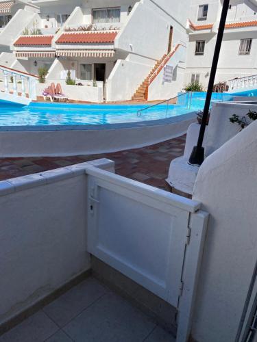 a white door on a wall next to a swimming pool at Casa MaGia in Playa de las Americas