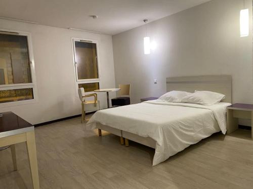 a bedroom with a bed and a table in it at Appartement Avenue de la Gare in Lourdes