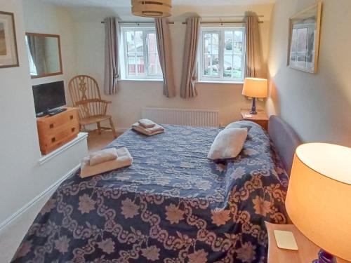 a bedroom with a large bed with a blue blanket at Homewood in Alnwick
