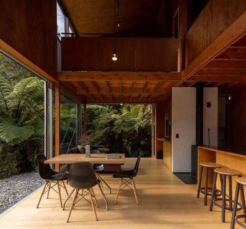 an open kitchen and dining room with a table and chairs at Punakaiki Forest Retreat in Punakaiki