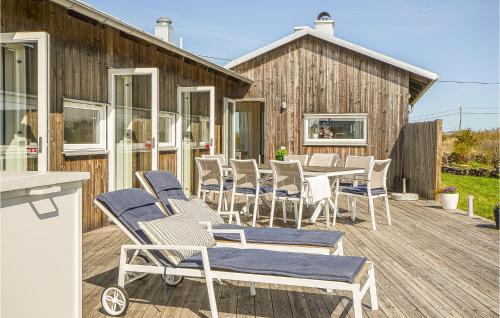 a deck with chairs and a table and a building at Stunning Home In Borgholm With Wifi in Borgholm