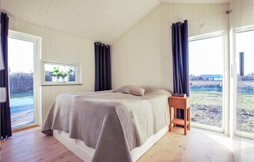 a bedroom with a bed and two large windows at Stunning Home In Borgholm With Wifi in Borgholm