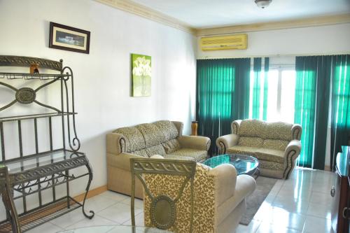 a living room with two chairs and a table at Embassy Deluxe apartment in Kingston