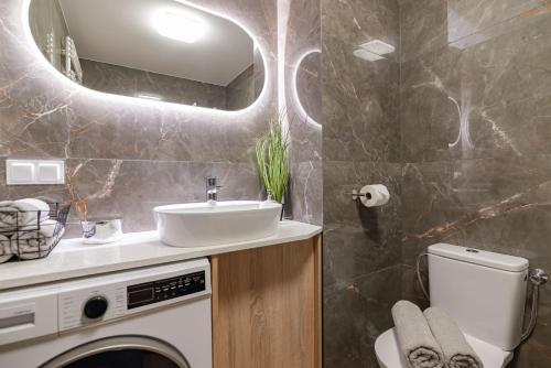 łazienka z umywalką i pralką w obiekcie Villa Garden Żołnierska w Olsztynie