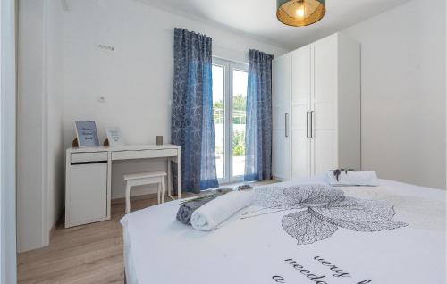 een witte slaapkamer met 2 bedden en een raam bij Lovely Home In Betina With Wifi in Betina