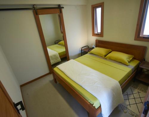 a bedroom with two beds and a mirror at Recanto dos Ipês 2 in Domingos Martins