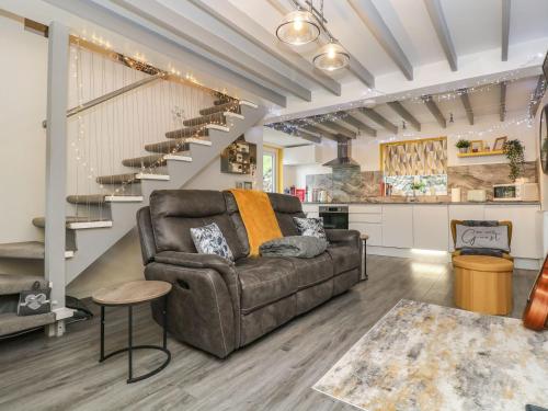 a living room with a couch and stairs at The Hideaway in Chacewater
