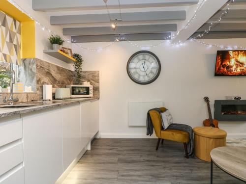 a kitchen with a clock on the wall and a chair at The Hideaway in Chacewater