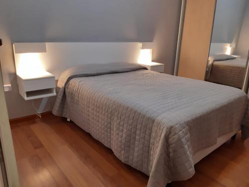 1 dormitorio con 1 cama y 2 mesitas de noche con lámparas en Gaudium en Paraná