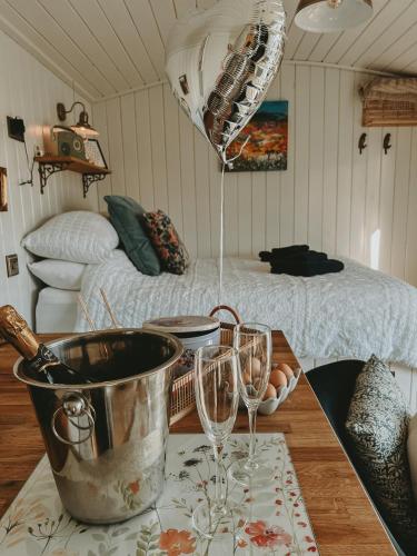 una cocina con una mesa con dos copas de vino. en Slieve Croob Glamping, en Ballyward