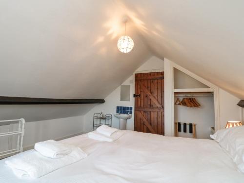 a bedroom with a white bed and a bathroom at Orchard Cottage in Whitby