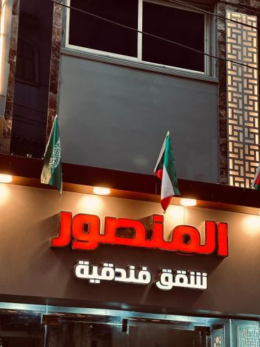 a sign for a jordan liquor store with two flags at Elmansour hotel apartments 82 in Mansoura