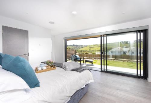 1 dormitorio con cama grande y ventana grande en The Shore, en Mawgan Porth