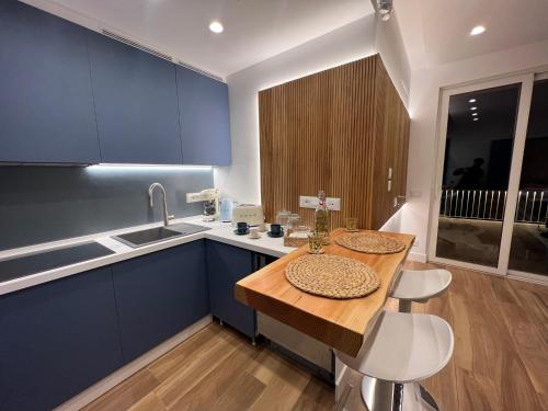 cocina con armarios azules y mesa de madera en SeaJewelsDeluxurySuite, en Amalfi