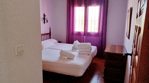 a bedroom with two beds with white sheets and towels at Casa Ian in Moraira