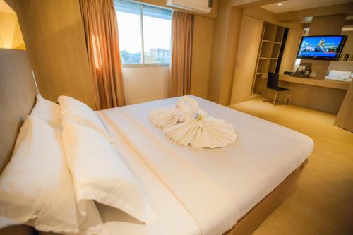 a hotel room with a bed with a towel on it at Golden City Rayong Hotel in Rayong