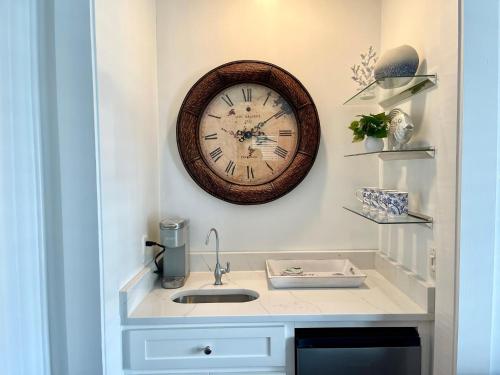 a clock hanging on a wall above a sink at A Wave From It All - 811 Ocean Blvd in Saint Simons