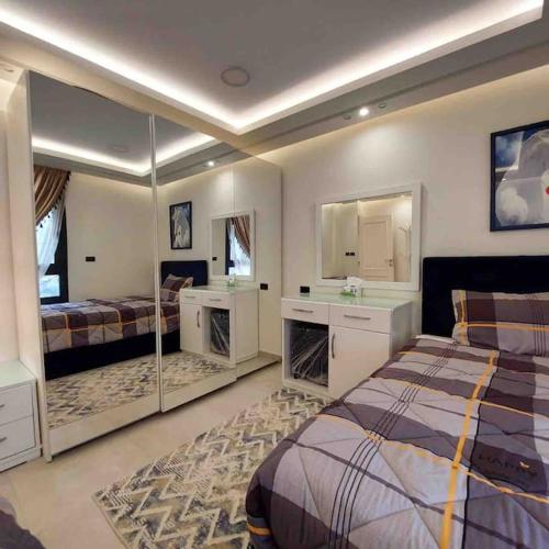 a bedroom with two beds and a sink and mirror at شقة فاخرة تشطيب فندقي حي المهندسين بالقاهرة in Cairo