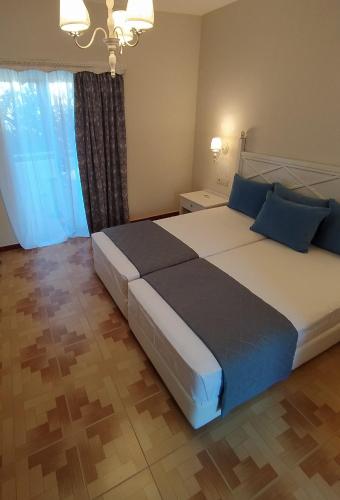 a bedroom with a large bed with blue pillows at Dionisia Apartments 2 in Kefalos