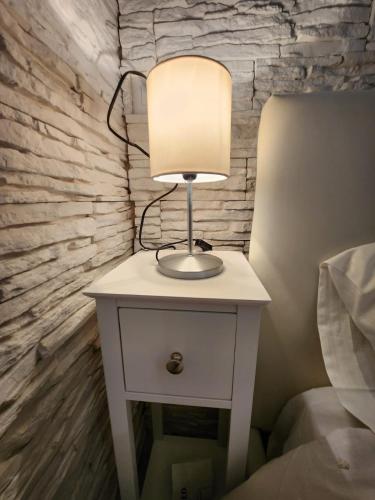 a lamp on a night stand next to a bed at DREAM HOUSE in Naples