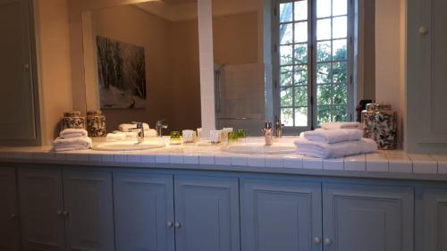 a bathroom with two sinks and a large mirror at Château de Bouesse en Berry in Bouesse