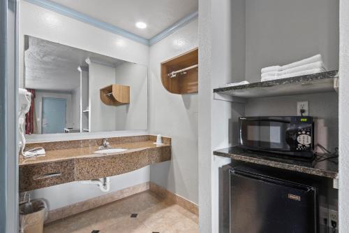 a bathroom with a sink and a microwave at Regency Inn Near Boardwalk & Hurlburt Field in Fort Walton Beach