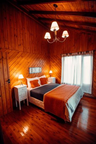 a bedroom with a large bed in a wooden room at Paraiso Patagónico Bungalows and Aparts in El Calafate