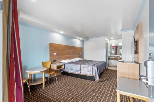 a hotel room with a bed and a table at Regency Inn Near Boardwalk & Hurlburt Field in Fort Walton Beach