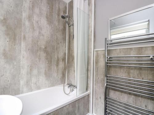 uma casa de banho com um chuveiro e um lavatório. em Jubilee Cottage em Penzance
