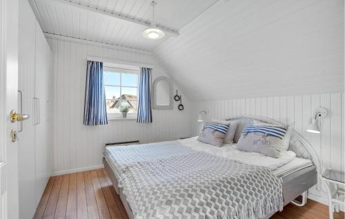 a white bedroom with a bed with blue curtains at Pet Friendly Home In Hvide Sande With House A Panoramic View in Havrvig