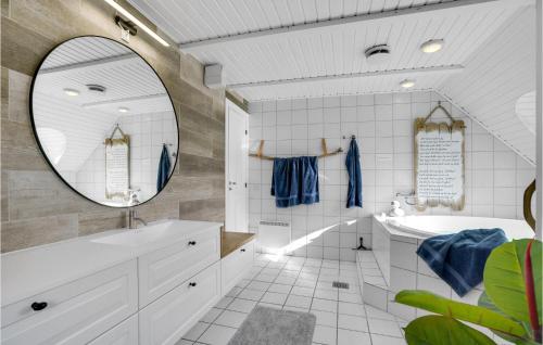 a bathroom with a tub and a sink and a mirror at Pet Friendly Home In Hvide Sande With House A Panoramic View in Havrvig