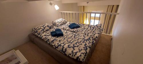 a bed with two blue pillows on it in a room at Pod Mewą Sopot Monte Cassino NEW in Sopot