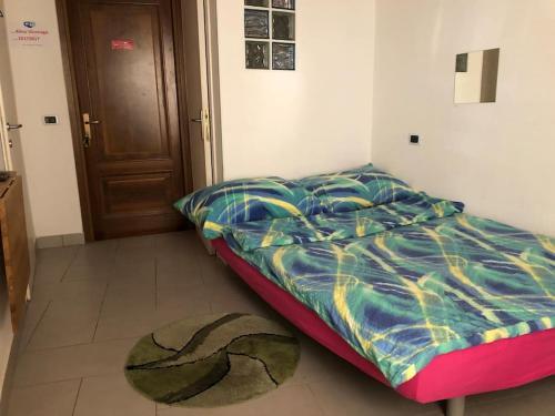 ein Schlafzimmer mit einem Bett und einem Teppich auf dem Boden in der Unterkunft Appartamento Viconago in Lavena Ponte Tresa